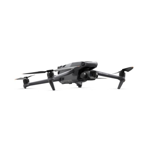 A DJI Mavic 3 Classic drone shown in a low-angle view, featuring a sleek gray design, a camera mounted on a gimbal at the front, and extended propeller arms with orange-tipped blades. The drone is placed against a plain white background.